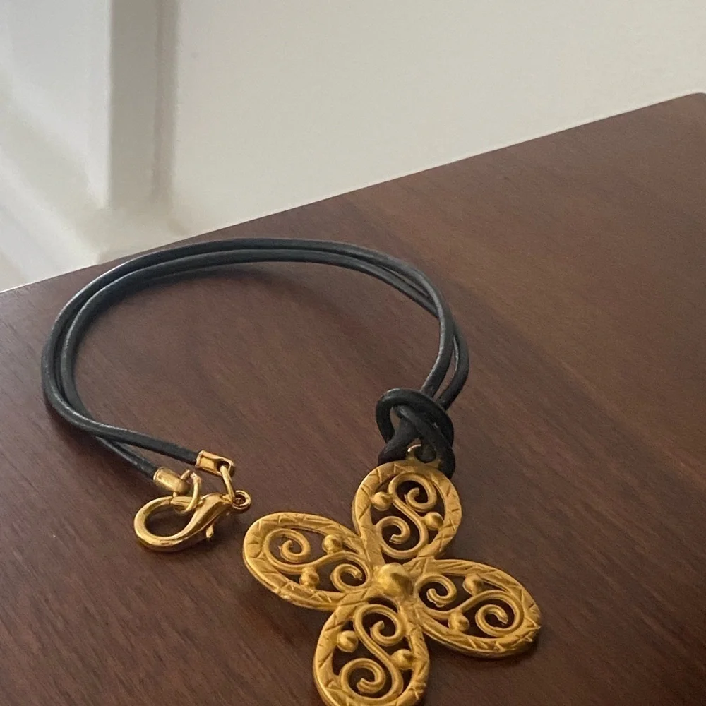 𝅺gold tone choker style necklace on leather cord